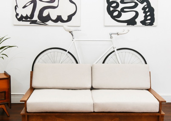 Bicicleta em apartamento atrás do sofá
